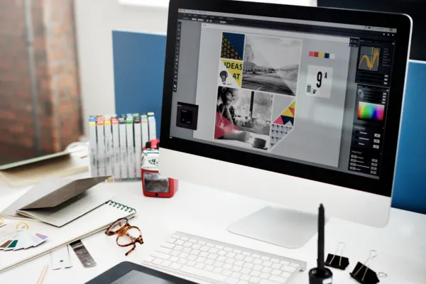 A modern computer monitor displaying creative digital layouts, showcasing services offered by graphic designers.