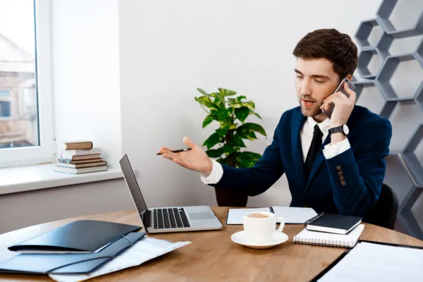 Business professional making a phone call for cold outreach, prospecting new clients, and building valuable business relationships.