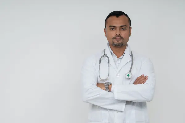Professional doctor wearing a white coat with stethoscope standing confidently for a healthcare profile photo.